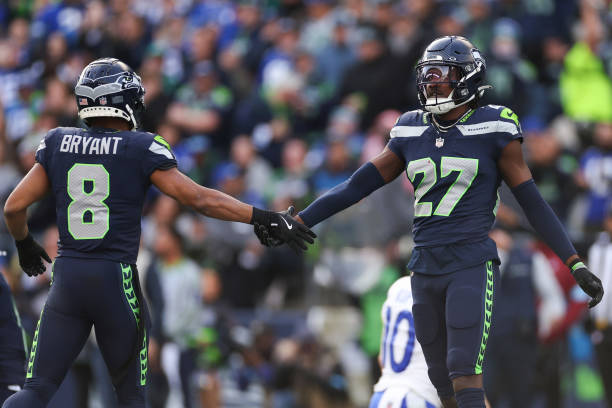  Riq Woolen #27 and Coby Bryant #8 of the Seattle Seahawks react during the first quarter of a game against 