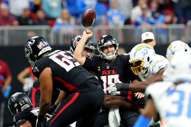 Otito Ogbonnia #93 of the Los Angeles Chargers forces a fumble against Kirk Cousins #18 of the Atlanta Falcons